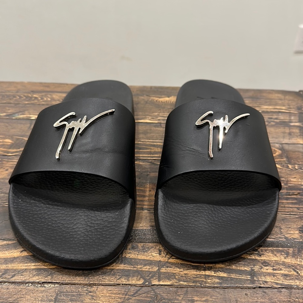 Giuseppe Zanotti Black leather sandal with silver Signature.
Metal Signature